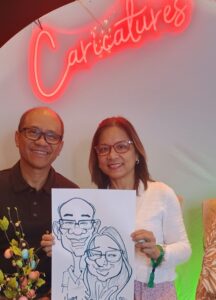 Wedding guests holding custom caricature drawing at san diego wedding reception